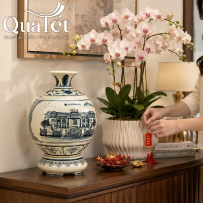 Bình hút lộc trưng bày tinh tế trên kệ gỗ cạnh chậu lan hồ điệp trắng