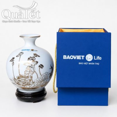 Bình hút tài lộc hoa sen vẽ vàng đặt cạnh hộp xi lót lụa màu xanh dương in logo Bảo Việt Nhân thọ