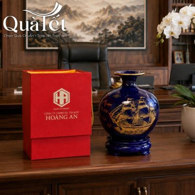 Bình hút lộc men coban vẽ vàng đặt cạnh hộp xi đỏ trên bàn làm việc bằng gỗ