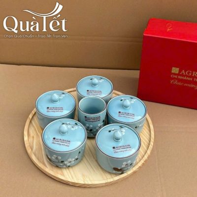 Bộ hũ mứt sứ men xanh sắp xếp cân đối trên khay gỗ tự nhiên có vân gỗ sáng màu
