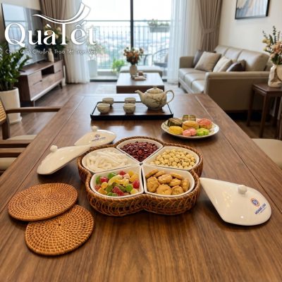 Bàn trà phòng khách hiện đại bày khay mứt chứa mứt dừa, hạt sen, cookies và bánh kẹo Tết