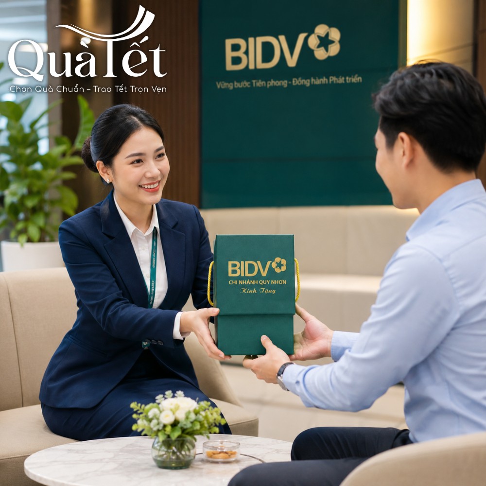 Nữ giao dịch viên ngân hàng lịch sự trao tặng hộp quà Tết ép kim logo vàng cho khách hàng