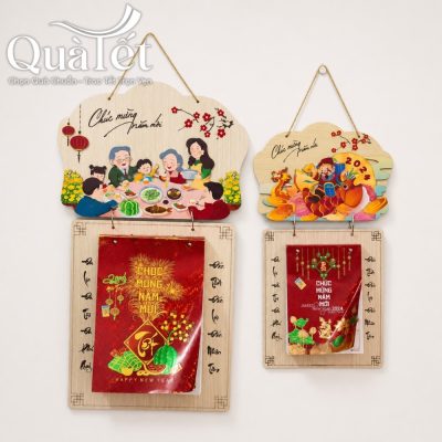 Hai mẫu lịch gỗ QT-LT03 treo tường cạnh nhau với chủ đề bữa cơm gia đình ngày Tết và Thần Tài đón lộc xuân