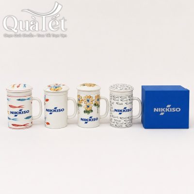 Bốn phiên bản ly sứ lọc trà QT-LS04 vẽ tay thủ công tinh xảo đặt cạnh hộp xi quà tặng màu xanh dương