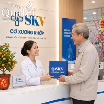 Nữ nhân viên y tế tại phòng khám SKV trao tặng hộp quà Tết đồng bộ màu xanh dương cho bệnh nhân lớn tuổi