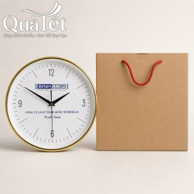Bộ sản phẩm đồng hồ QT-DH02 đặt cạnh hộp đựng bằng giấy carton màu kraft tối giản có quai xách màu đỏ